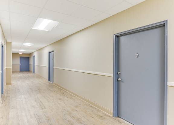 A long hallway with a blue door on the right. at Academy at Drexel Apartments, Illinois