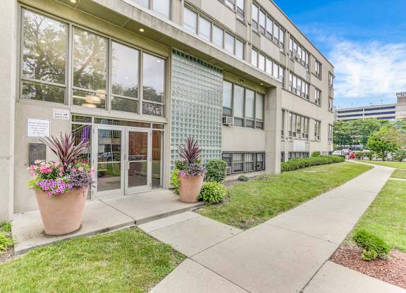 A building with a glass facade and a walkway in front. at Academy at Drexel Apartments, Illinois, 60637