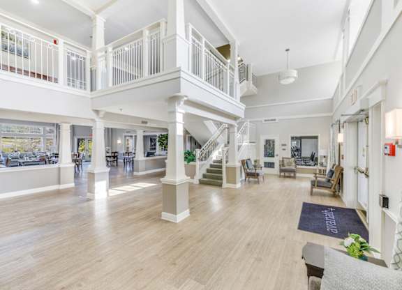 A spacious living room with a staircase and a balcony at Manor at Victoria Park, Temple Hills, MD 20748