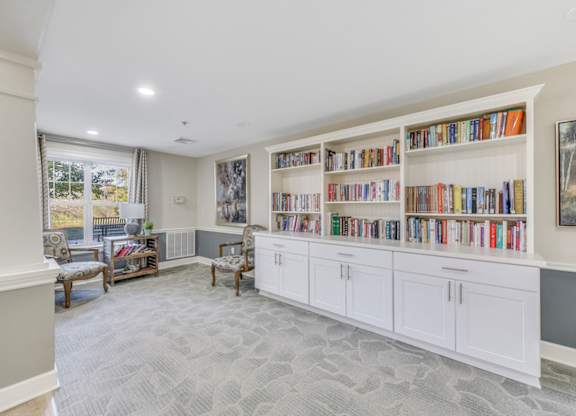 A room with a bookshelf filled with books at Manor at Victoria Park, Temple Hills