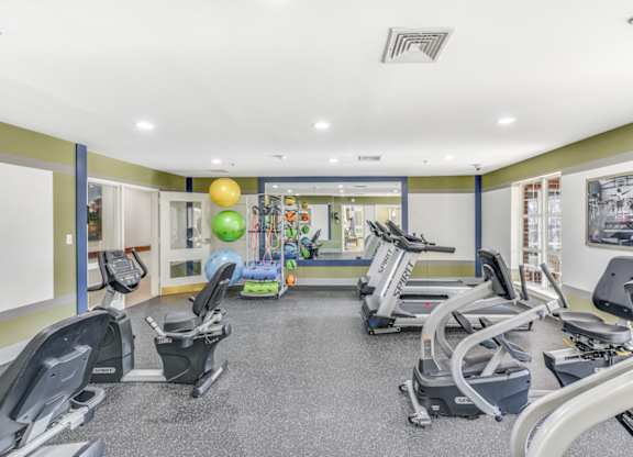 A gym with treadmills, exercise bikes, and elliptical machines at Manor at Victoria Park, Temple Hills, 20748