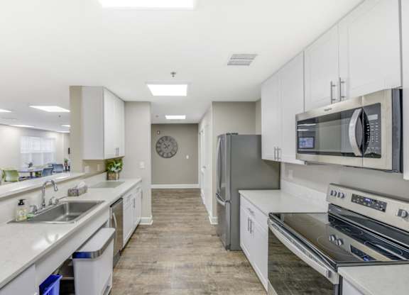 Resident kitchen with white cabinets and appliances at Manor at Victoria Park, Temple Hills