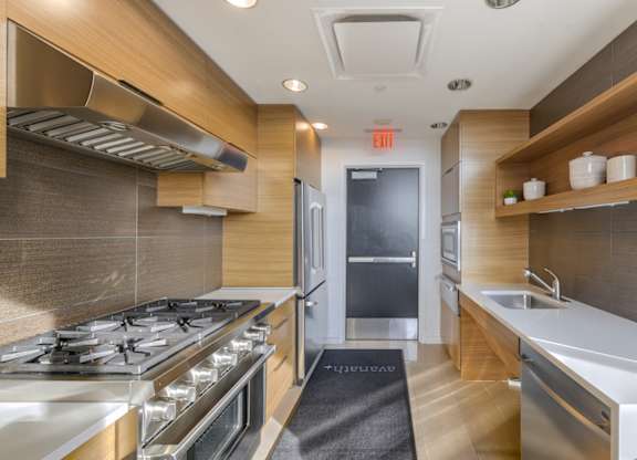 A modern kitchen with a stove top oven and a sink. at Affinity at 2M, Washington, 20002