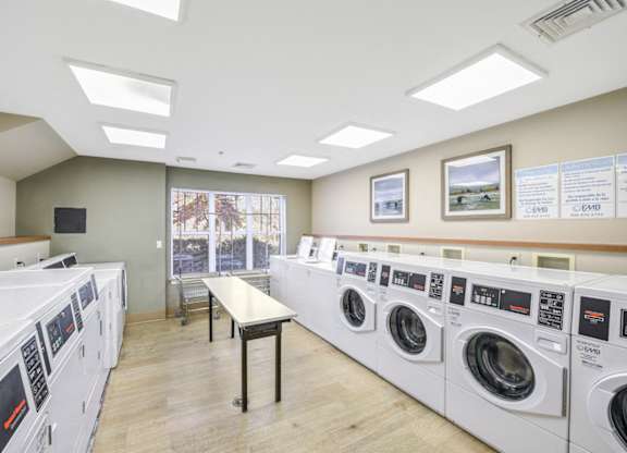 A laundromat with rows of washers and dryers at Manor at Victoria Park, Temple Hills