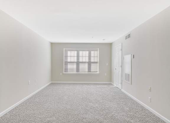 A room with a carpeted floor and a window with blinds at Manor at Victoria Park, Temple Hills, MD 20748