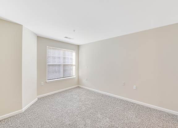 A room with a carpeted floor and a window with blinds at Manor at Victoria Park,  Maryland, 20748