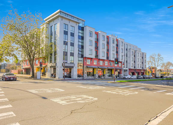 A street view of a multi-story building with a car parked in front. at Acton Courtyard, Berkeley, California