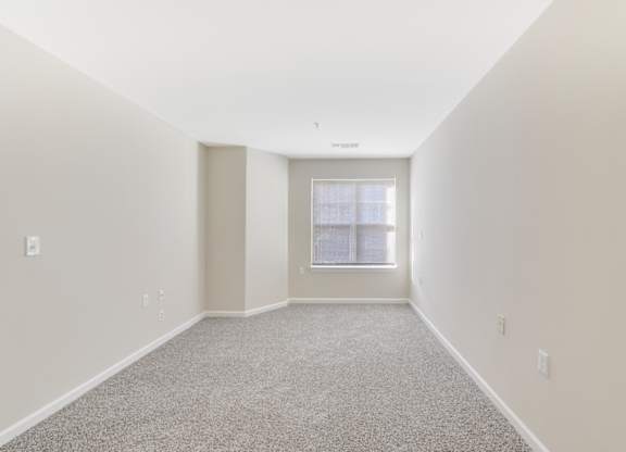 A room with a carpeted floor and a window at Manor at Victoria Park, Temple Hills, 20748