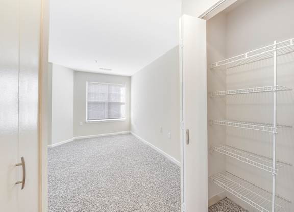 A white closet with shelves and a door at Manor at Victoria Park, Temple Hills