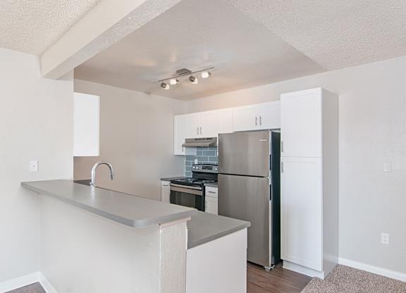 A kitchen with white cabinets and stainless steel appliances.