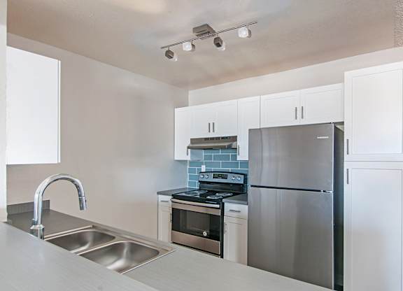 A modern kitchen with stainless steel appliances and white cabinets.