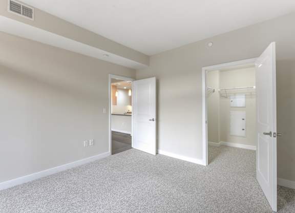 A spacious room with a carpeted floor and two open doors. at Affinity at 2M, Washington, 20002
