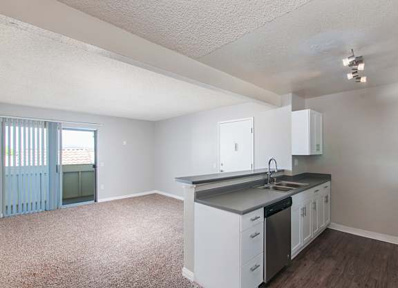 A kitchen with white cabinets and a black countertop.