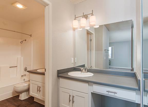 A bathroom with a sink, mirror, and toilet.