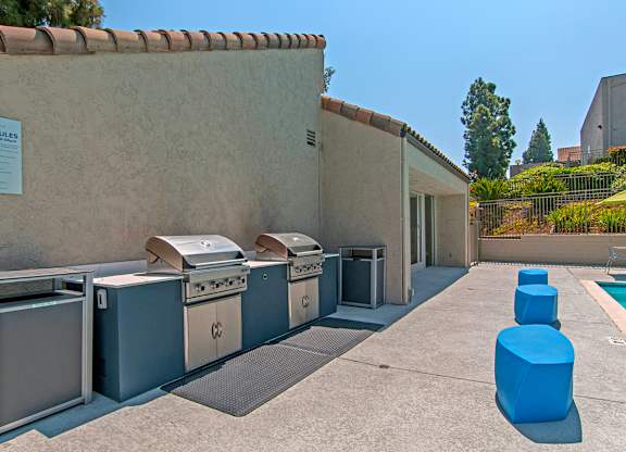 A pool area with a sign that says "POOL RULES" and several hot tubs.