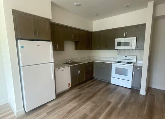 A kitchen with a white fridge and a white oven at Rivo Apartments, Sacramento, CA, 95815