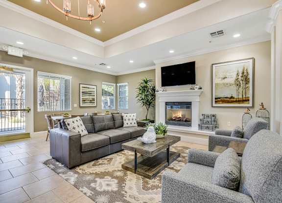 A living room with a grey couch, a coffee table, and a fireplace.