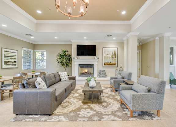 A living room with a grey couch and a fireplace.