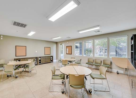 A room with tables and chairs and a white ceiling.