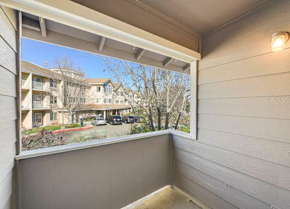 A view from a window of apartment buildings and trees.