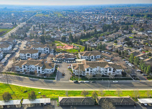 A bird's eye view of a residential area with houses and a parking lot.