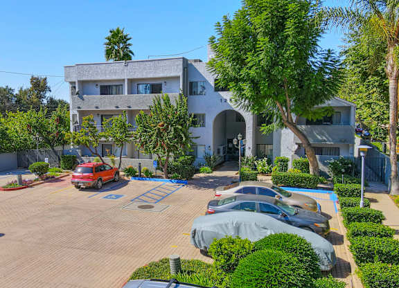 A modern house with a red car parked in front.