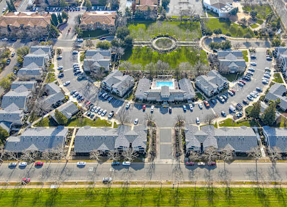 A bird's eye view of a residential area with houses and a central park.
