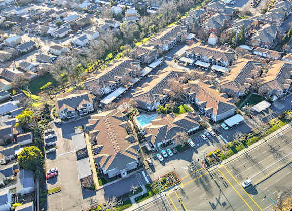 A bird's eye view of a residential area with houses and a highway.