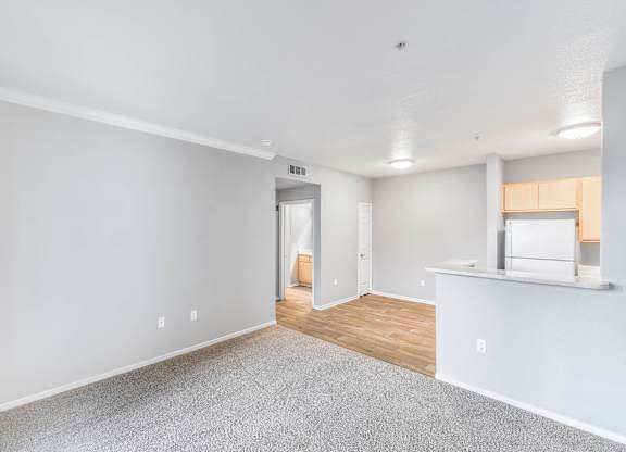 A spacious room with a carpeted floor and a window.