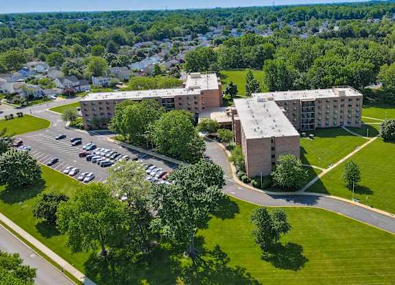 A large building with a parking lot in front of it at Menlo Manor Apartments, Edison, New Jersey