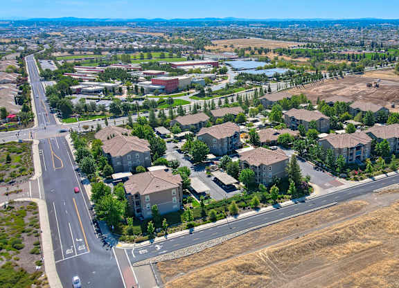 A large, empty field sits in the foreground of a residential area.