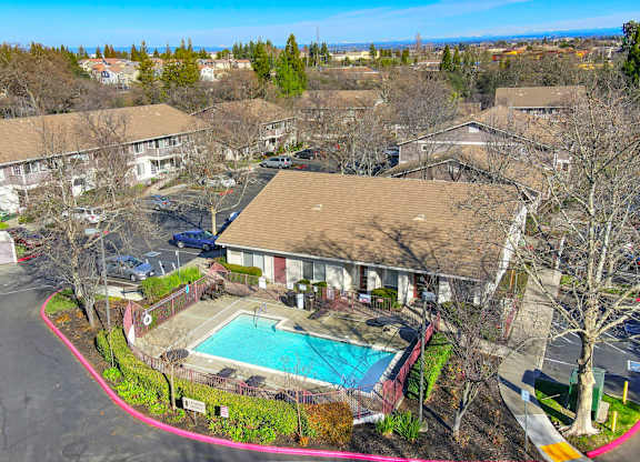 A swimming pool is surrounded by a red border in a residential area.