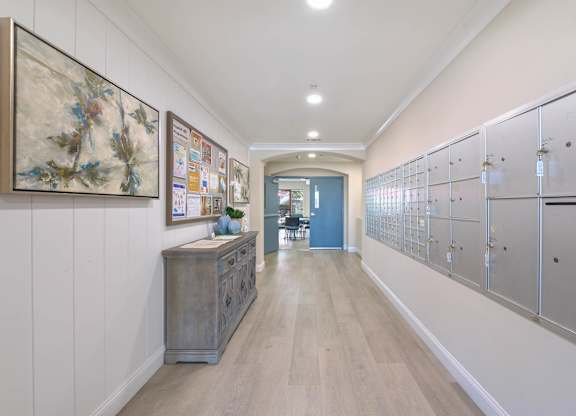 A hallway with a blue door and a cabinet with drawers.