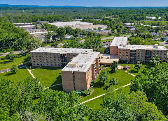 A large building complex surrounded by trees at Menlo Manor Apartments, Edison, NJ, 08820
