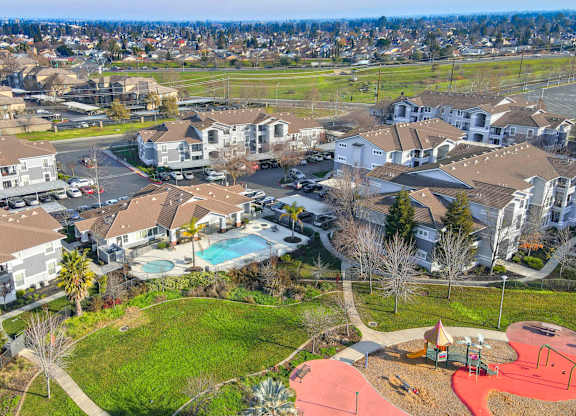 A bird's eye view of a residential area with a swimming pool and playground.