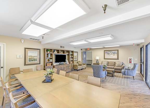 A large dining table with chairs and a fireplace in the background.