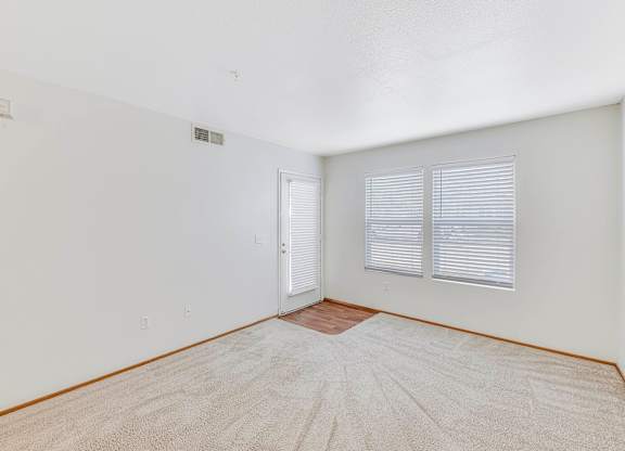 A room with a carpeted floor and a door with a window.