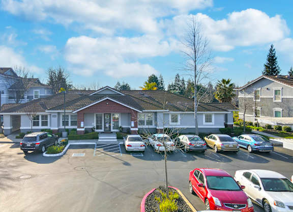 A parking lot with cars and a building in the background.