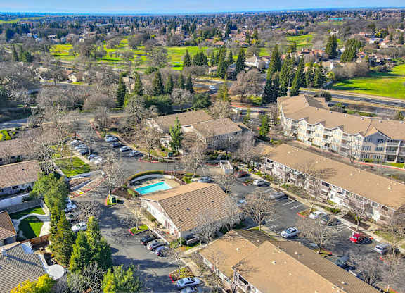A bird's eye view of a residential area with houses and a pool.