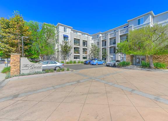 The entrance to a residential building with a sign that reads "The Grove."