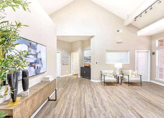 Community lounge entrance with a flat screen TV on the wall and a wooden floor. at Cooper's Crossing, Irving, 75038