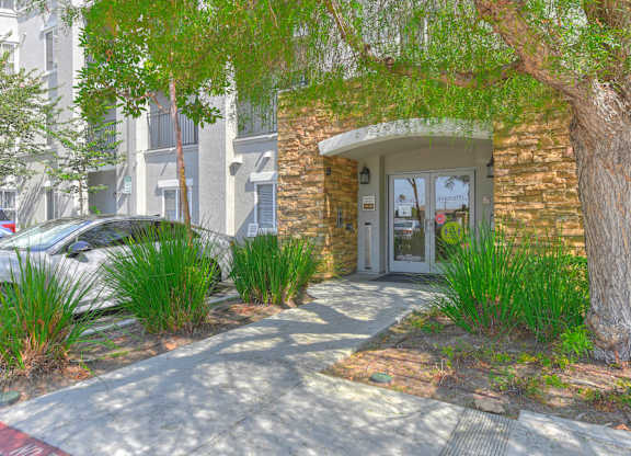 A building with a stone archway entrance and a tree in front.