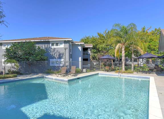A swimming pool in a backyard with a house in the background.