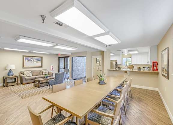 A spacious room with a long table and chairs.