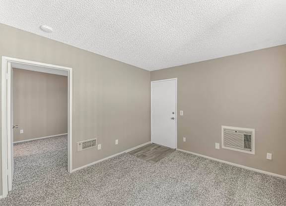 A room with a white door and carpeted floor.