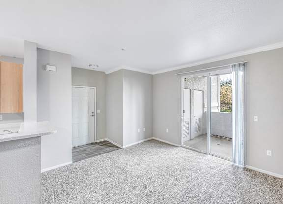A spacious, empty room with a carpeted floor and white walls.