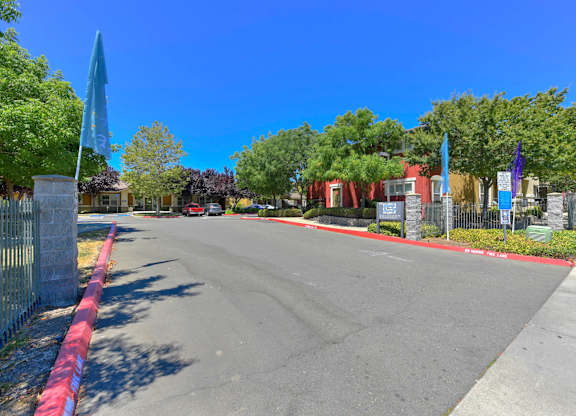 A street view with a red curb and a metal fence at Hurley Creek Apartment Homes, Sacramento, CA, 95834