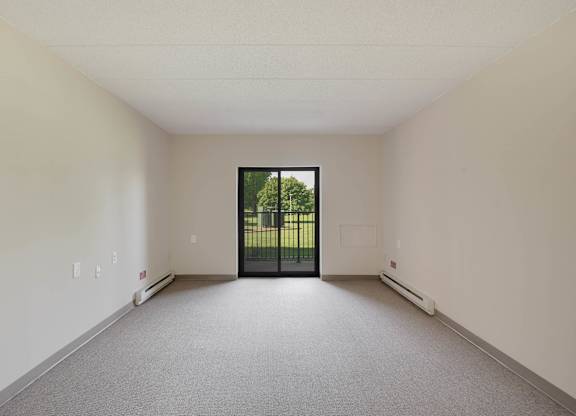 A room with a grey carpet and a black door at Menlo Manor Apartments, Edison