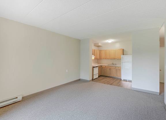 Empty room with a kitchen in the background at Menlo Manor Apartments, New Jersey, 08820
