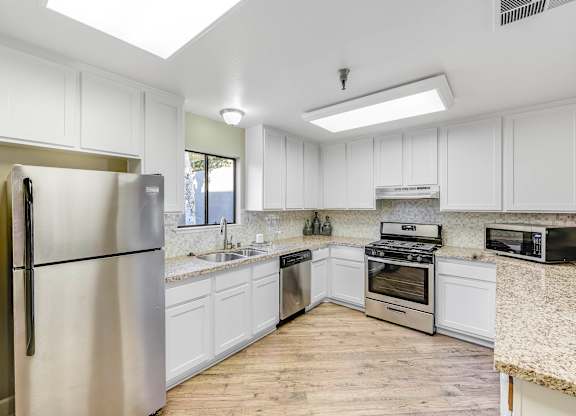 A kitchen with white cabinets and stainless steel appliances.
